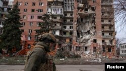 Një ushtar ukrainas kalon pranë ndërtesave të shkatërruara të banimit në Pokrovsk. Fotografi nga arkivi. 