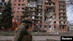 Украин сарбазы Ресей зымыраны қиратқан үйдің жанынан өтіп барады. Покровск, 6 наурыз.