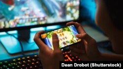 Një fëmijë duke luajtur një lojë në telefon. Fotografi ilustruese. 