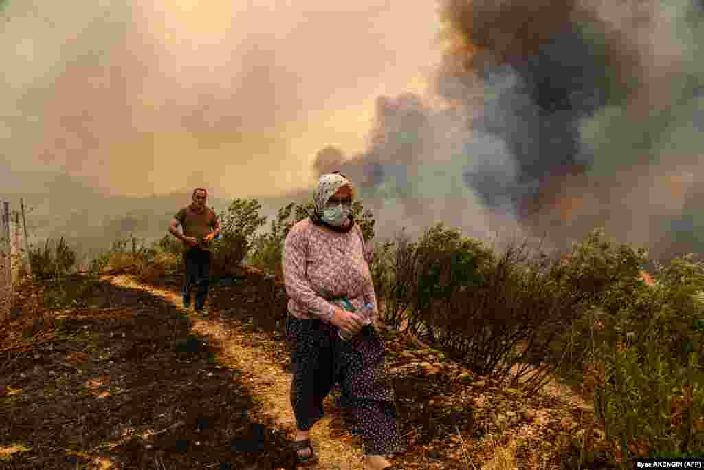Mještani prolaze pored požara nedaleko od grada&nbsp;Manavgata, 29. juli.