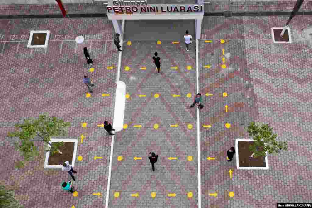 Средношколци влегуваат во училиште, почитувајќи ги мерките за физичко растојание на 18 мај 2020 година во Албанија. Албанија постепено ги напушта своите мерки за заклучување,