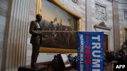 Знаме в подкрепа на кампанията на Тръмп, положено в ръцете на статуя на 38-я президент Джералд Форд.