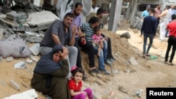 Palestinci pored srušenih kuća u Beit Hanounu u sjevernom pojasu Gaze, 21. maja 2021. 