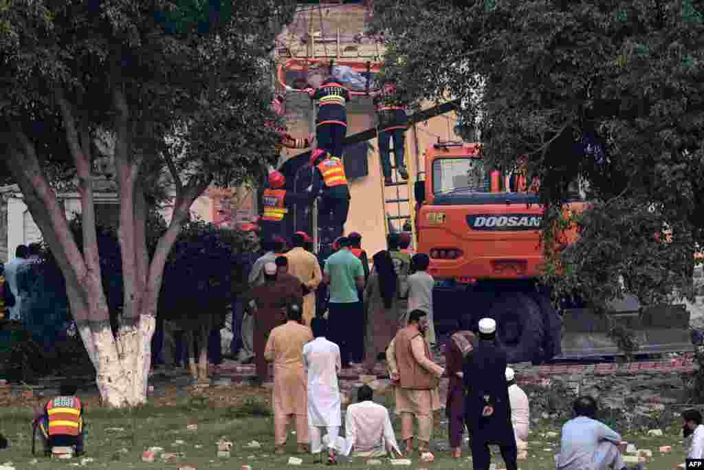 Спасувачи го преместуваат тело на жртва извадена од под урнатините на зградата на владиниот здравствен и образовен комплекс по индиските напади во Муридке