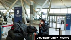 Një pasagjere në Aeroportin John F. Kennedy në SHBA, pasi u njoftua për anulimin e fluturimeve për shkak të përhapjes së variantit Omicron. 24 dhjetor 2021. 