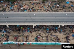 ათასობით მიგრანტი ელოდება თავშესაფარს აშშ-ში დელ რიოს საერთაშორისო ხიდთან ახლოს მდინარე რიო გრანდეს გადაკვეთის შემდეგ. ტეხასი, აშშ, 2021 წლის 18 სექტემბერი. გადაღებულია დრონით. სააგენტო როიტერსი.