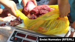 Kyrgyzstan - Kurman Ait in Osh. The ceremony of the sacrifice of a camel. Distribution of gifts (meat, food) to poor families. Osh, October 15, 2013