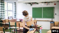 Fertőtlenítenek egy tanteremben a fővárosi Krúdy Gyula Angol - Magyar Két Tanítási Nyelvű Általános Iskolában 2020. október 28-án.
