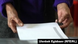 Избиратель опускает бюллетень во время выборов президента Кыргызстана. 2017 год. 