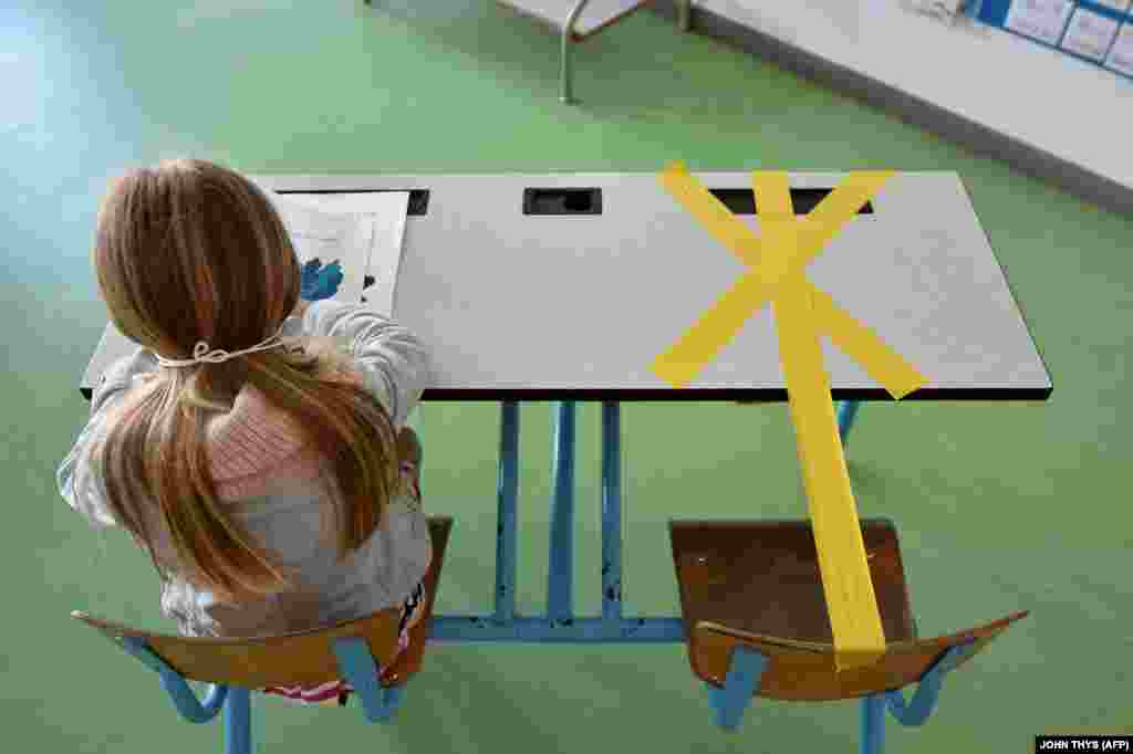 Ученичка од основното училиште &bdquo;Сент-Кроа&ldquo; работи на нејзиното биро обележано со лента за да се обезбеди безбедно растојание.