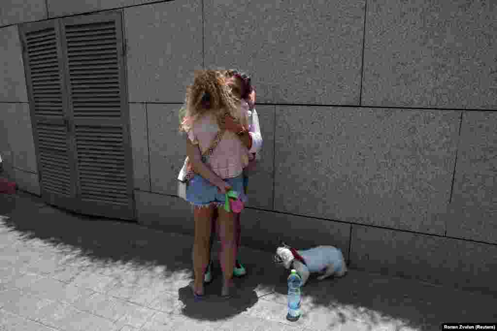 Dy persona duke u përqafuar teksa shtetas të huaj bëheshin gati të largoheshin nga Izraeli me autobusë përmes Egjiptit, pas një sulmi raketor iranian, në Tel Aviv, më 17 qershor.