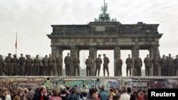Graničari stoje na vrhu Berlinskog zida ispred Brandeburške kapije, istočni Berlin, 11. novembar 1989.