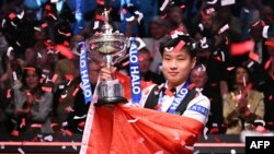 Джао Синтонг позира със световната титла по снукър и китайския национален флаг в "Крусибъл тиатър" в Шефилд, Великобритания, 5 май 2025 г.