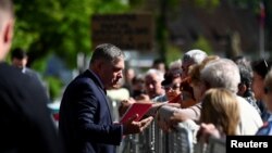 Premierul slovac Robert Fico vorbește cu câțiva oameni adunați în fața Casei de Cultură din orașul Handlova, cu câteva momente înainte să fie împușcat, 15 mai 2024.