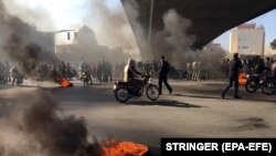 Протестующие против повышения цен на бензин иранцы заблокировали трассу в Исфахане. 16 ноября 2019 года.