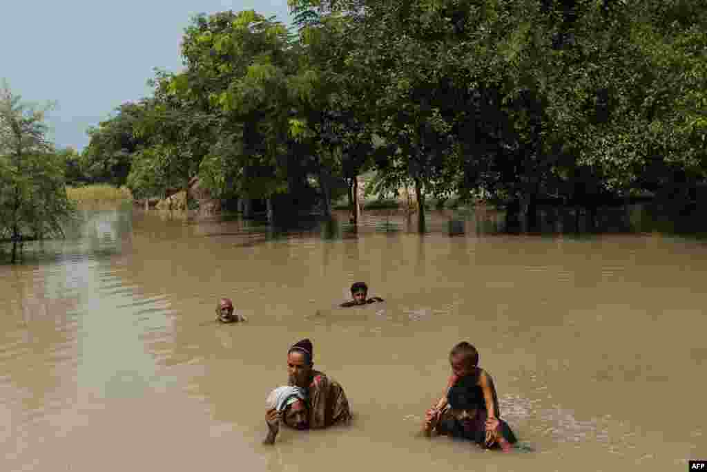 Mještani prelaze bujicu nakon obilnih kiša u pakistanskoj pokrajini Punjab, 21. avgusta. Više od 20 ljudi je poginulo u monsunskim kišama, gdje su padavine uništile čitava sela. Više od 400 ljudi je izgubilo živote.