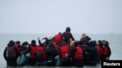Група од повеќе од 40 мигранти се качуваат на гумен чамец, додека го напуштаат брегот на северна Франција за да го преминат Ла Манш. 24 ноември 2021 година.
