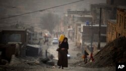 Женщина несет воду в пластиковой емкости, поднимаясь по склону по пути к своему дому в Кабуле, Афганистан. На этой фотографии из архива от 27 декабря 2010 года (AP Photo/Altaf Qadri, архив)