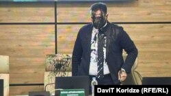 Predsednik Centraalne izborne komisije Gruzije Giorgi Kalandarišvili poliven crnom tečnošću tokom sednice komisije u Tbilisiju, 16. novembra 2024. 