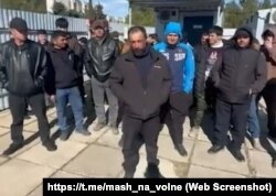 Группа российских строителей, которые пожаловались на долги по зарплате за строительство общежитий Севастопольского госуниверситета, 19 марта 2025 года. Скриншот с видео