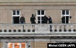 Полицајци на еден од балконите на Универзитетот карлов во центарот на Прага, 21.12.2023