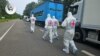 International Red Cross representatives walk past a convoy of refrigerator trucks carrying the bodies of Ukrainian soldiers being repatriated on June 11.
