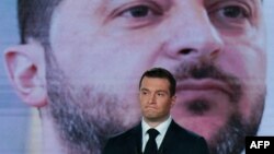 Jordan Bardella, președintele „Reuniunii Naționale” și candidatul extremei drepte la funcția de prim-ministru al Franței, în timpul unei dezbateri electorale pe 27 iunie, având pe fundal imaginea președintelui ucrainean Volodimir Zelenski.