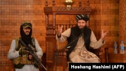 Imam u džamiji Abdul Rahman u Kabulu govori pored naoružanog talibana, 20. avgust 2021. 