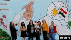  Iraki keresztények egy Ferenc pápát ábrázoló falfestmény előtt a pápa iraki látogatása előtt. Bagdad, Irak, 2021. február 22.
