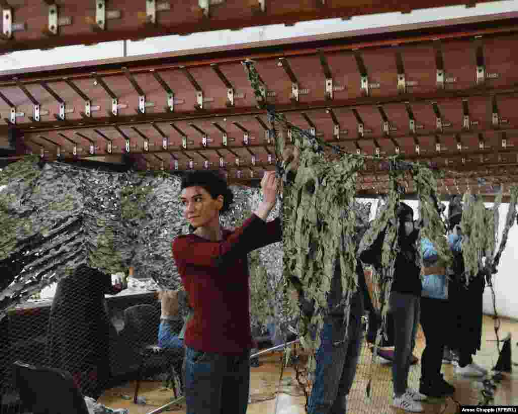 Yeva Gevorgian az Örmény Nemzeti Filharmonikus Zenekar nagybőgőse egyike azoknak az elismert zenészeknek, akik ugyanabban az épületben önkénteskednek most, ahol egyébként a koncertjeiket szokták tartani. A zenész azt mondta a Szabad Európának, hogy nagy szükség volt a álcahálókra a fronton. &quot;Ez nem olcsó dolog és Örményországnak nincs sok pénze&quot; - mondta.