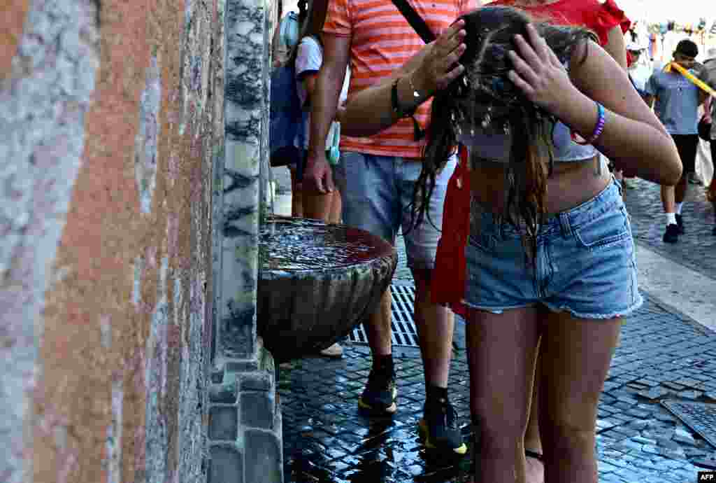 Vasárnap az olasz egészségügyi minisztérium 27 monitorozott városból 21-et a legmagasabb hőségriasztás alá helyezett, köztük olyan felkapott turistacélpontokat, mint Róma, Milánó és Nápoly. A képen egy lány a Vatikánban próbálja felfrissíteni magát egy kút vizével június 27-én