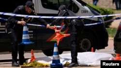 Polițiști spanioli lângă cadavrul lui Andrei Portnov, un avocat ucrainean care a fost împușcat mortal, pe 21 mai 2025, de bărbați înarmați neidentificați în fața unei școli din Madrid, Spania.