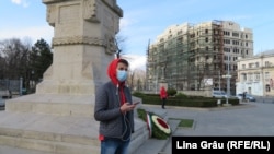 Un tânăr cu masca pe față asteaptă lângă monumentul lui Ștefan cel Mare din centrul Chișinăului. Autoritățile au decretat cod rosu de urgență sanitară sâmbătă, 14 martie 2020.