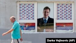Muškarac prolazi pored plakata sa likom Aleksandra Vučića, lidera Srpske napredne stranke i predsednika Srbije, na jednoj zgradi u Beogradu jula 2021. 