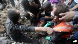 მაშველები ცდილობენ დაშავებული პალესტინელი ბიჭის ამოყვანას ნანგრევებიდან. ბურეიჯის ლტოლვილთა ბანაკი, ღაზის სექტორი, 2 ნოემბერი, 2023.