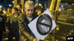 Demonstrant spaljuje transparent sa likom bivšeg premijera Nikole Gruevskog, 14. april 2016.