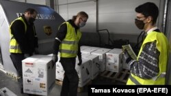 Nagyjából 70 ezer adag Pfizer-BioNTech oltást pakolnak ki a Liszt Ferenc reptéren, 2020. december 30-án. 12 nappal később kiderült, hogy a gyártó túltöltötte az ampullákat, így az Európai Gyógyszerügynökség engedélyezte, hogy egy ampullából 5 helyett 6 embert oltsanak be.