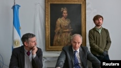 Федералният главен прокурор на Мар дел Плата Даниел Адлер, помощник-прокурорът Карлос Мартинес и кураторът Ариел Басано говорят пред медиите на фона на намерената картина "Портрет на дама" в Мар дел Плата, Аржентина, 3 септември 2025 г.