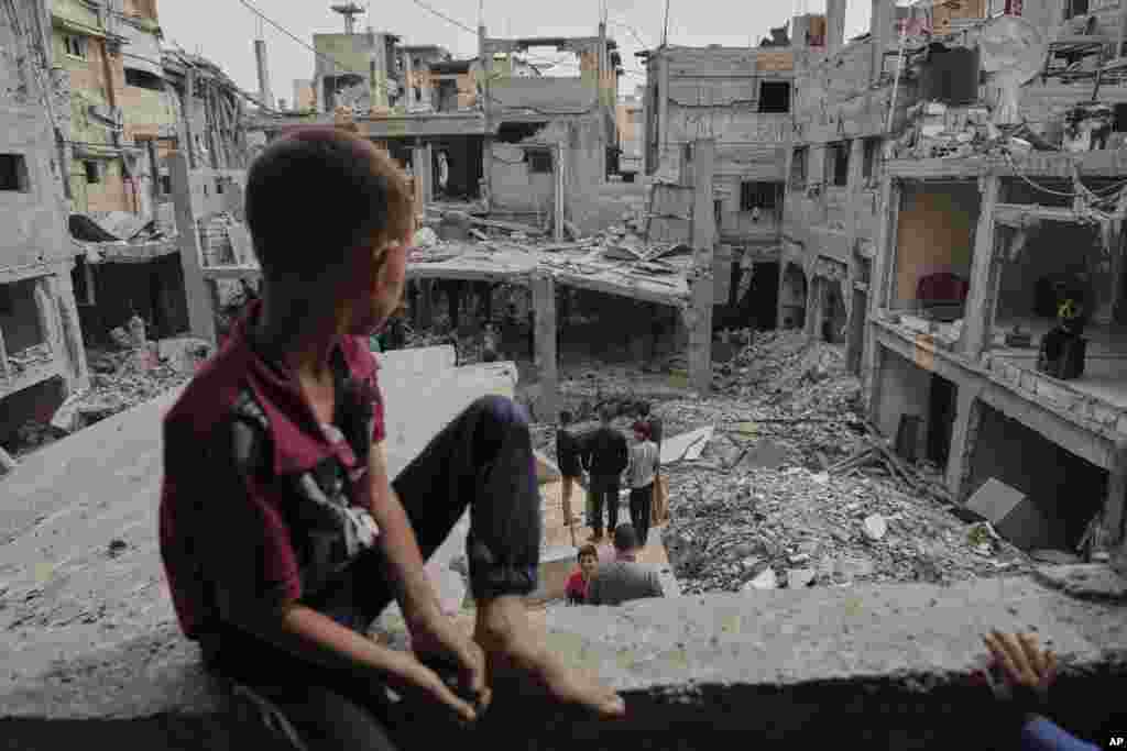 Palestinski dječak gleda ruševine kuće porodice Al-Lahham, uništene u izraelskim zračnim napadima u Khan Younisu, Pojas Gaze, u četvrtak, 15. maja 2025.