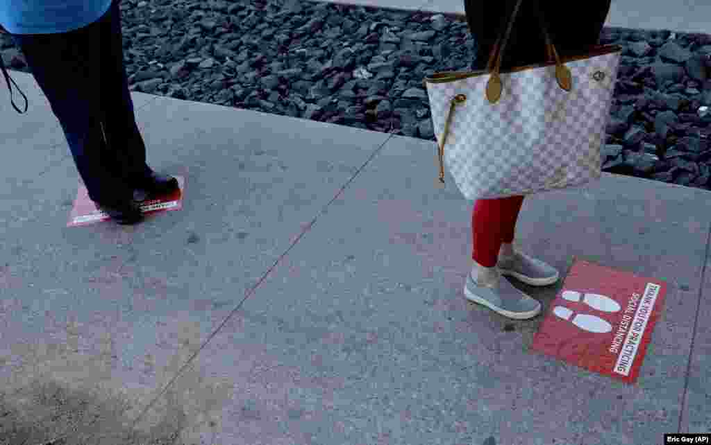 Znakovi koji usmeravaju ljude kako bi održali socijlanu distancu dok čekaju u redu za kupovinu u Ostinu u Teksasu, 25. marta.