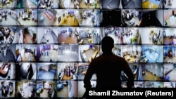 Az orosz Központi Választási Bizottság moszkvai központjában figyeli egy férfi a szavazóhelyiségbe kihelyezett kamerákat 2021. szeptember 19-én