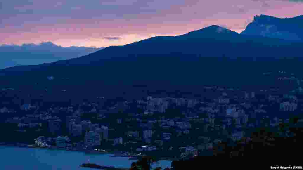 Солнце садится за грядой гор. Вид из Ялты, май 2020 года