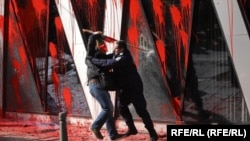 Ofițeri de poliție împing un protestatar în fața clădirii CE din Sofia.