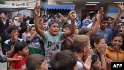 Palestinska djeca slave ispred bolnice Shuhada al-Aqsa u Deir al-Balahu u centralnom Pojasu Gaze, nakon vijesti o novom sporazumu o prekidu vatre u Gazi, 9. oktobra 2025.