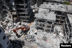 Personalul de salvare lucrează în locul în care a căzut o rachetă iraniană, Bat Yam, Israel, 15 iunie 2025.