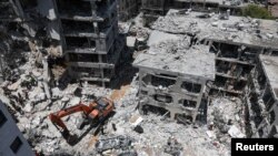 Personalul de salvare lucrează în locul în care a căzut o rachetă iraniană, Bat Yam, Israel, 15 iunie 2025.