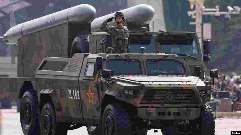 Stratégiai csapásmérő alakulat egyik katonája CJ-20A cirkálórakétákkal a háta mögött tiszteleg