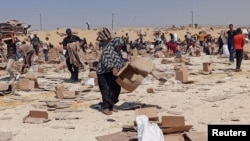 Palestinienii adunați pentru a colecta ce a mai rămas din ajutoarele de la centrul de distribuție al Fundației Umanitare Gaza, susținută de SUA, în Rafah, în sudul Fâșiei Gaza, 5 iunie 2025. 