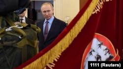 Руският президент Владимир Путин до знаме, на което са изобразени Ленин и Сталин, 6 март 2020 г.