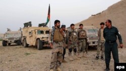 Members of the Afghan security services take positions during an operation in an area retaken from the Taliban, in Nawa district of Helmand Province, on April 18.
